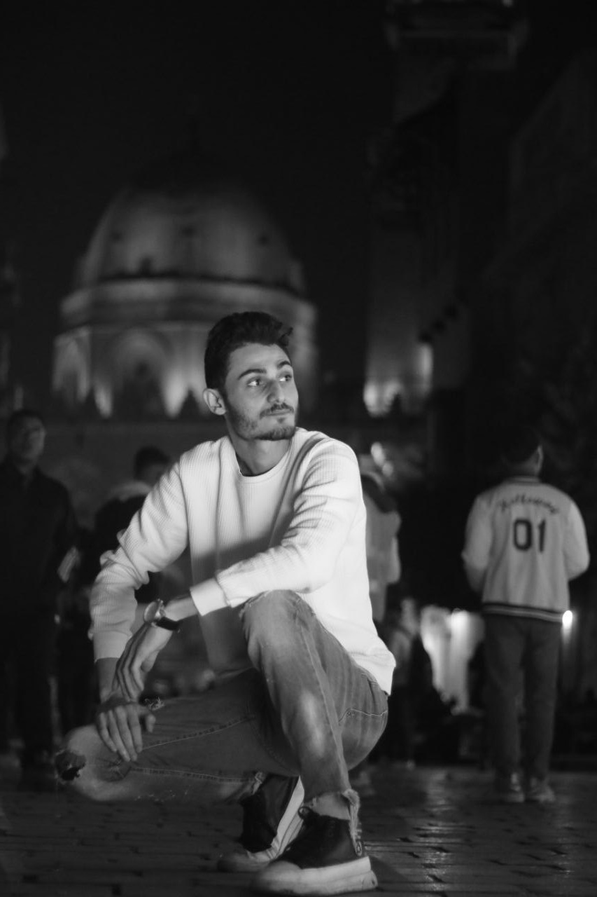 A man in a alice blue shirt with a thinking expression